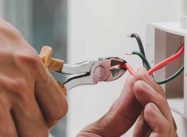 Electrician cutting electrical wires during installation work by Xceed Electrical