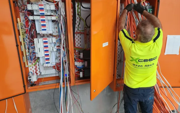 Xceed Electrical technician working on wiring inside an electrical control panel, ensuring safe installation and reliable home security systems.