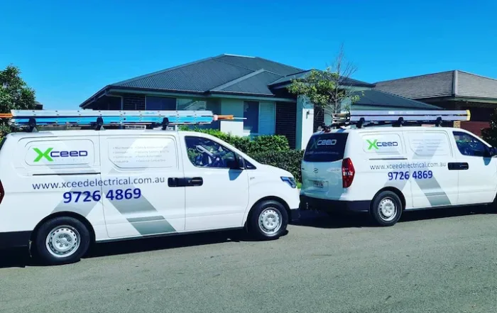 Xceed Electrical service vans parked outside a residential home